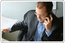 Middle age man, sitting at a desk and answering questions about a company formations over the phone.